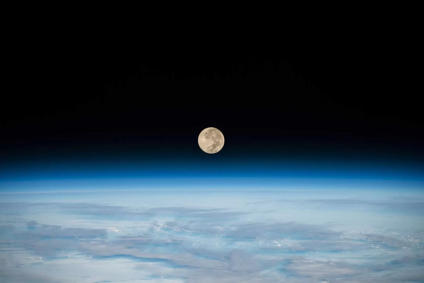 Photo prise par la NASA depuis l'ISS (Station Spatiale Internationale) où l'on voit la lune à la surface de l'atmosphère bleue de la Terre